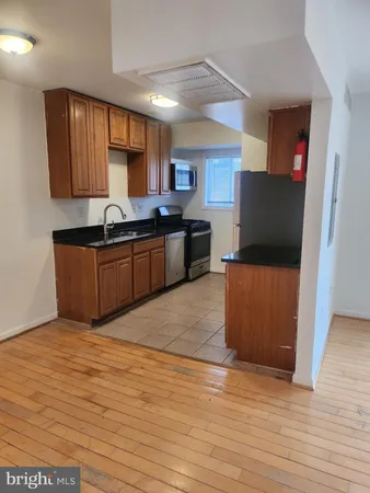 a kitchen with stainless steel appliances granite countertop a sink a stove top oven a counter space and cabinets