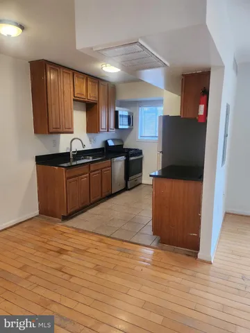 a kitchen with stainless steel appliances granite countertop a sink a stove top oven a counter space and cabinets