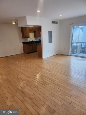 an empty room with wooden floor and furniture