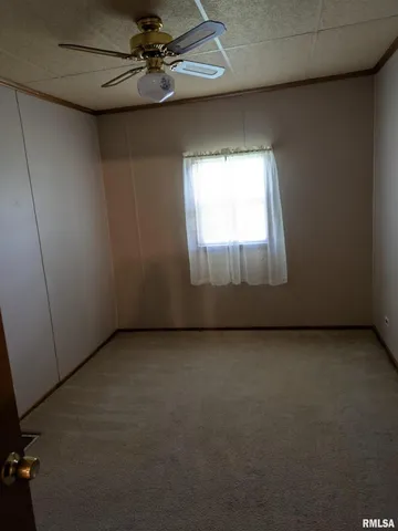 an empty room with a ceiling fan and window