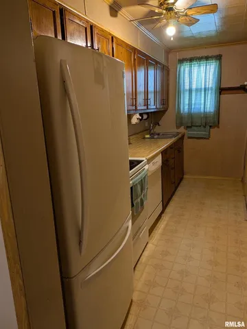 a kitchen with a refrigerator a sink and cabinets