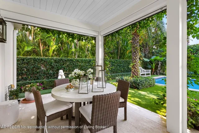a living room with patio furniture and garden view