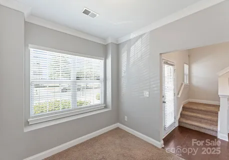 a view of an empty room with stairs and a window