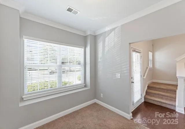 a view of an empty room with stairs and a window