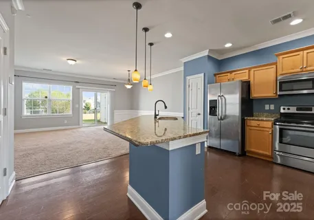 a kitchen with stainless steel appliances granite countertop a sink a stove and a refrigerator