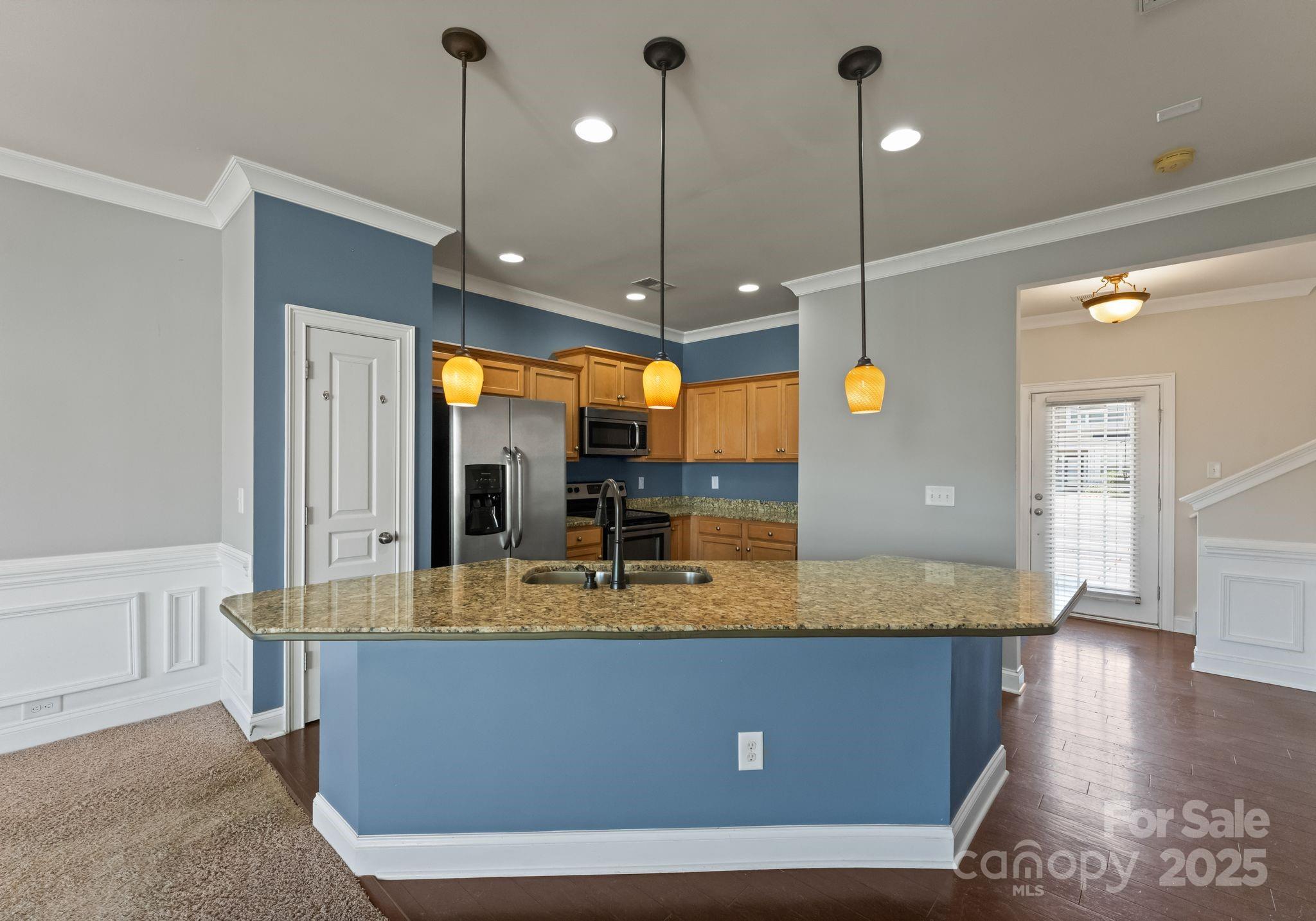 193 Halton Crossing Drive Southwest Concord, NC 28027 - Photo 7 of 20 a view of a kitchen with kitchen island a counter top space a sink and wooden floor