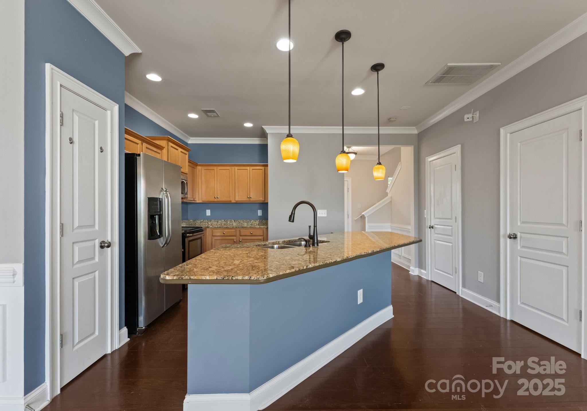 193 Halton Crossing Drive Southwest Concord, NC 28027 - Photo 8 of 20 a kitchen with stainless steel appliances granite countertop a sink a refrigerator and a wooden floor
