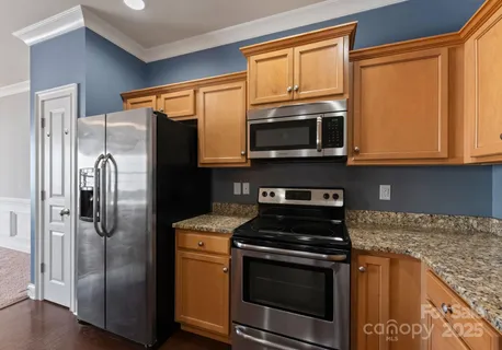 a kitchen with stainless steel appliances granite countertop a refrigerator stove and microwave