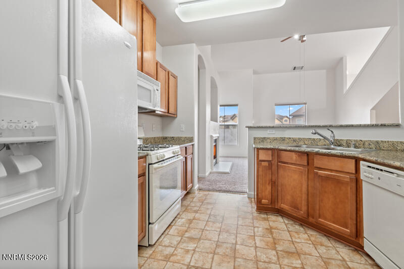 1325 South Meadows Parkway, Unit 621 Reno, NV 89521 - Photo 6 of 18 a kitchen with stainless steel appliances granite countertop a refrigerator and a stove top oven