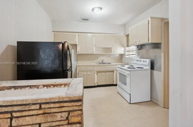 a kitchen with cabinets stainless steel appliances and sink