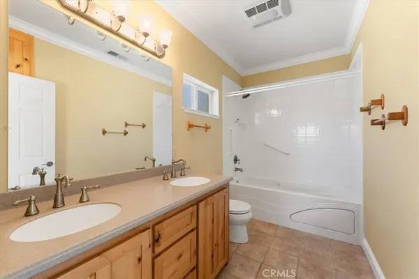 a bathroom with a granite countertop sink a toilet a mirror and shower