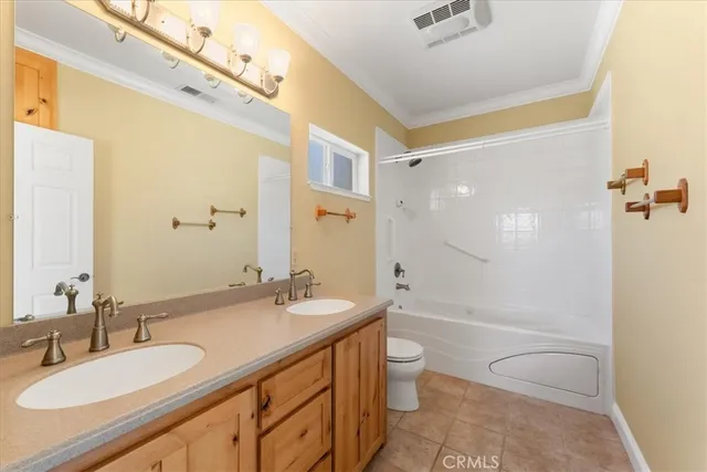 a bathroom with a granite countertop sink a toilet a mirror and shower