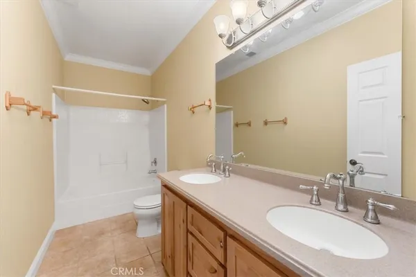 a bathroom with a granite countertop sink a toilet a mirror and shower