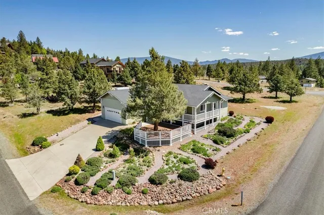 a view of a house with a yard and lawn chairs