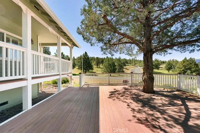 a view of a small deck with wooden floor and fence