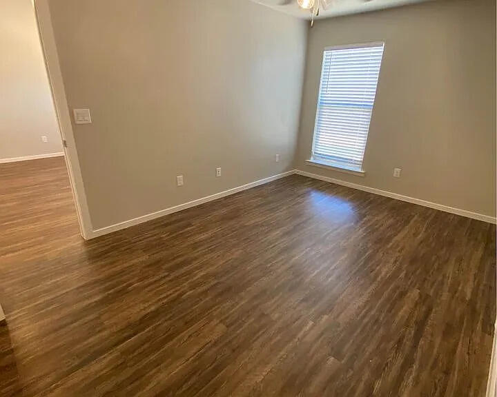 2101 Langford Avenue, Unit B Lubbock, TX 79407 - Photo 3 of 5 a view of an empty room with wooden floor and a window