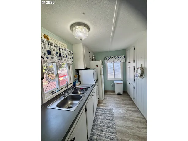 a view of a hallway with workspace and a window