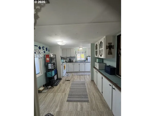 a view of a kitchen with wooden floor and a sink
