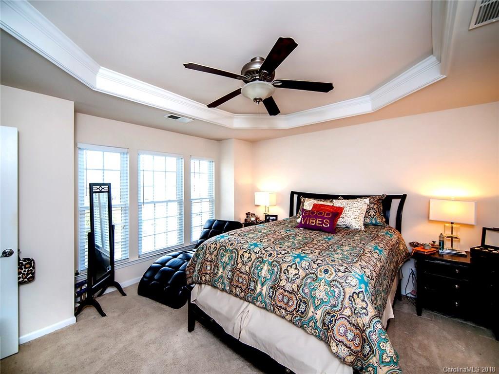 566 6th Baxter Crossing Fort Mill, SC 29708 - Photo 14 of 25 a bedroom with a bed and a chandelier