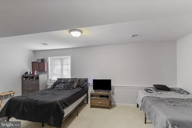 a living room with a bed furniture and a flat screen tv