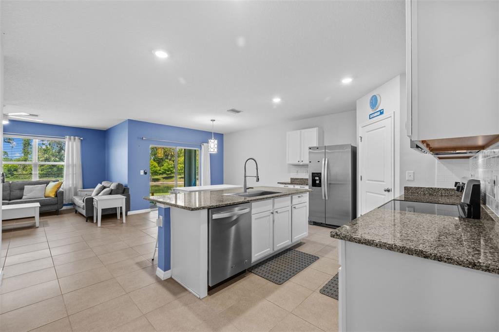 2721 Greenleaf Terrace Parrish, FL 34219 - Photo 21 of 65 a kitchen with stainless steel appliances granite countertop a sink and a refrigerator