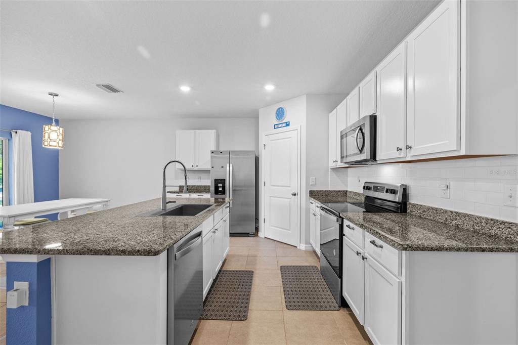 2721 Greenleaf Terrace Parrish, FL 34219 - Photo 22 of 65 a kitchen with stainless steel appliances granite countertop a sink stove and cabinets