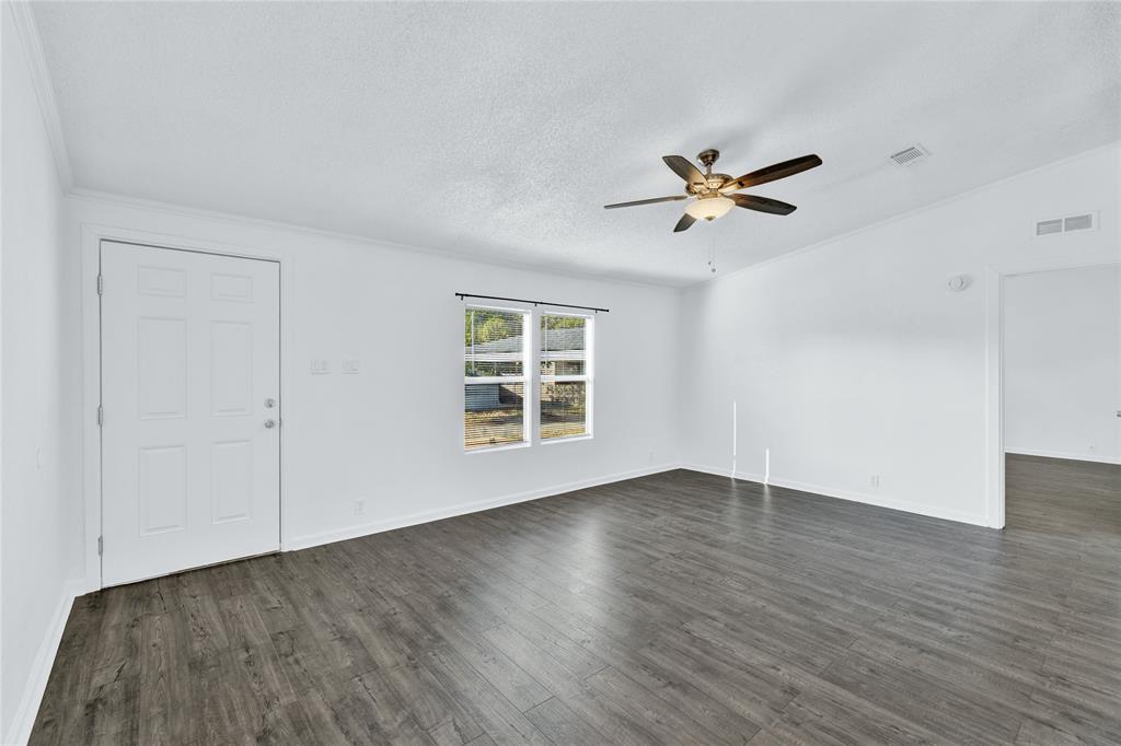312 6th Street Joshua, TX 76058 - Photo 13 of 33 an empty room with wooden floor ceiling fan and windows