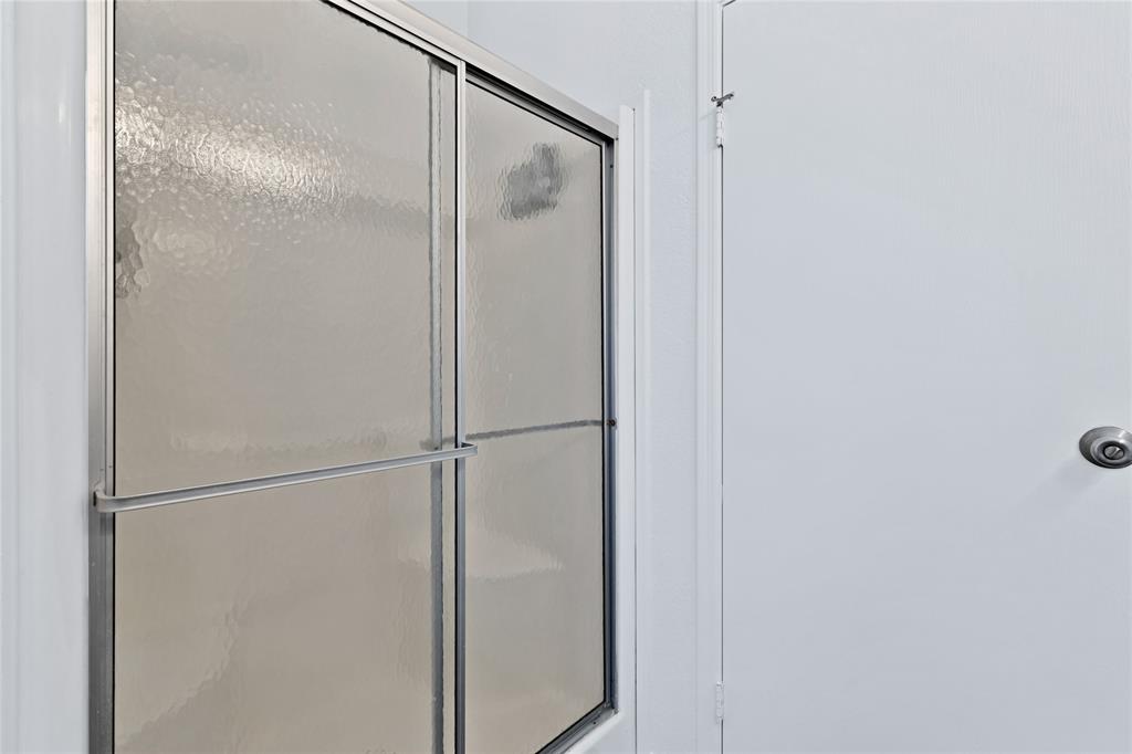 312 6th Street Joshua, TX 76058 - Photo 21 of 33 a bathroom with a glass shower door