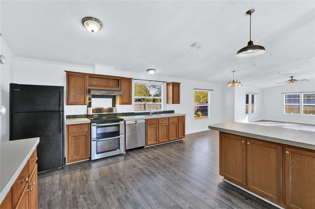 312 6th Street Joshua, TX 76058 - Photo 4 of 33 a large kitchen with a center island wooden floor and stainless steel appliances