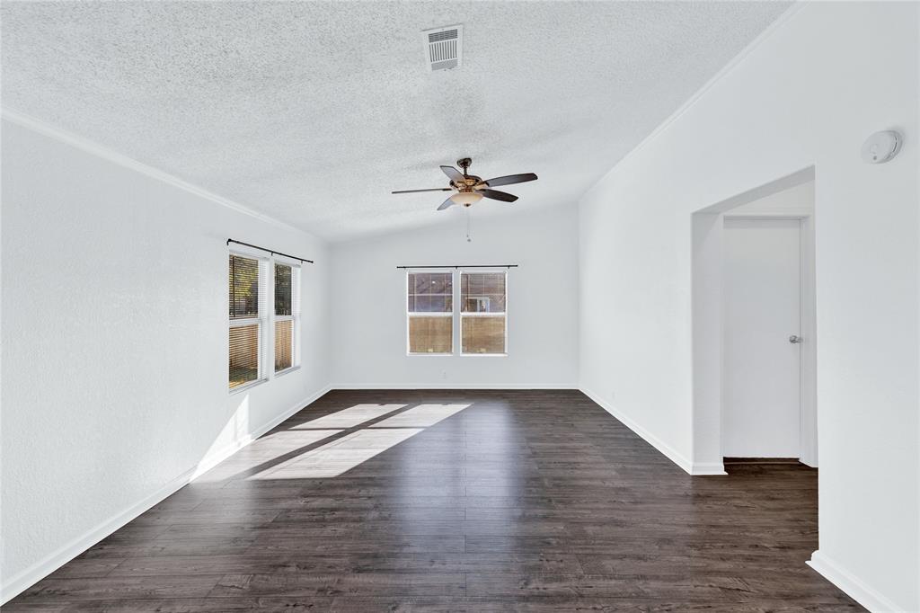 312 6th Street Joshua, TX 76058 - Photo 6 of 33 an empty room with wooden floor chandelier and windows