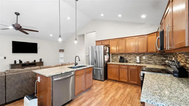 a kitchen with stainless steel appliances granite countertop a sink stove and refrigerator