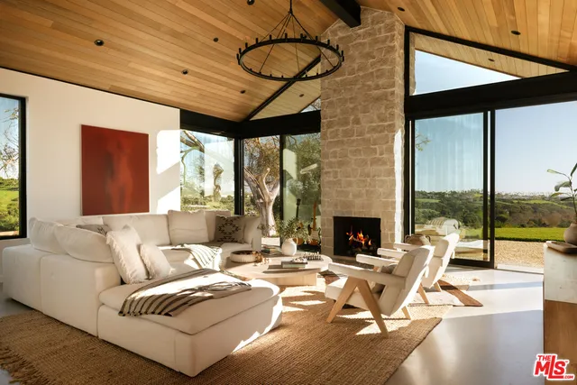a living room with fireplace furniture and a floor to ceiling window