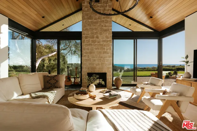 a living room with patio furniture and a floor to ceiling window