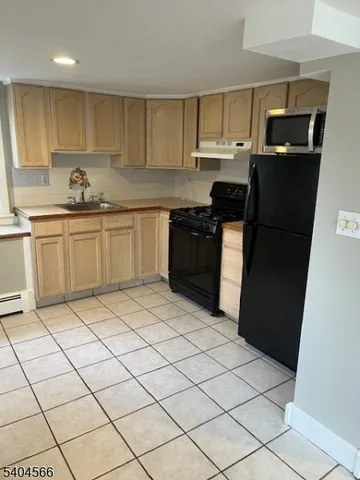 a kitchen with a sink a refrigerator and cabinets