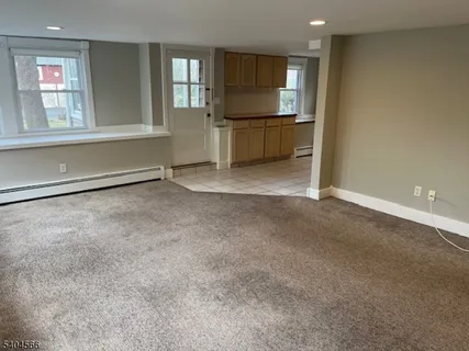 an empty room with windows & cabinet