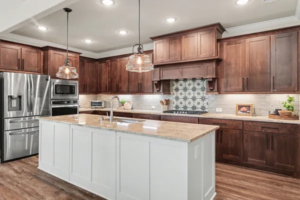 a kitchen with stainless steel appliances granite countertop a sink refrigerator and cabinets