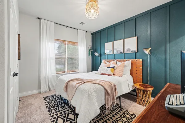 a bedroom with a bed and a chandelier