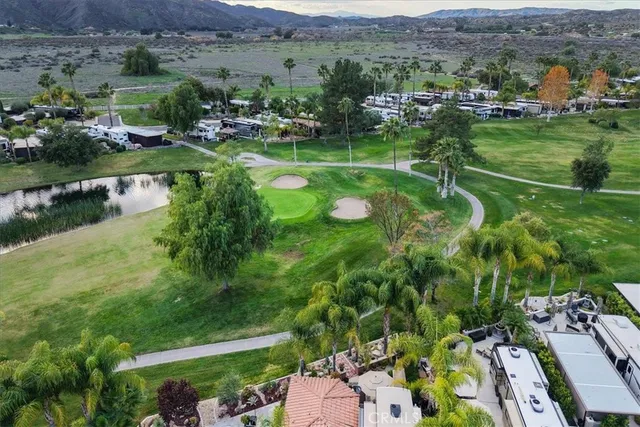an aerial view of green landscape with trees houses and lake view