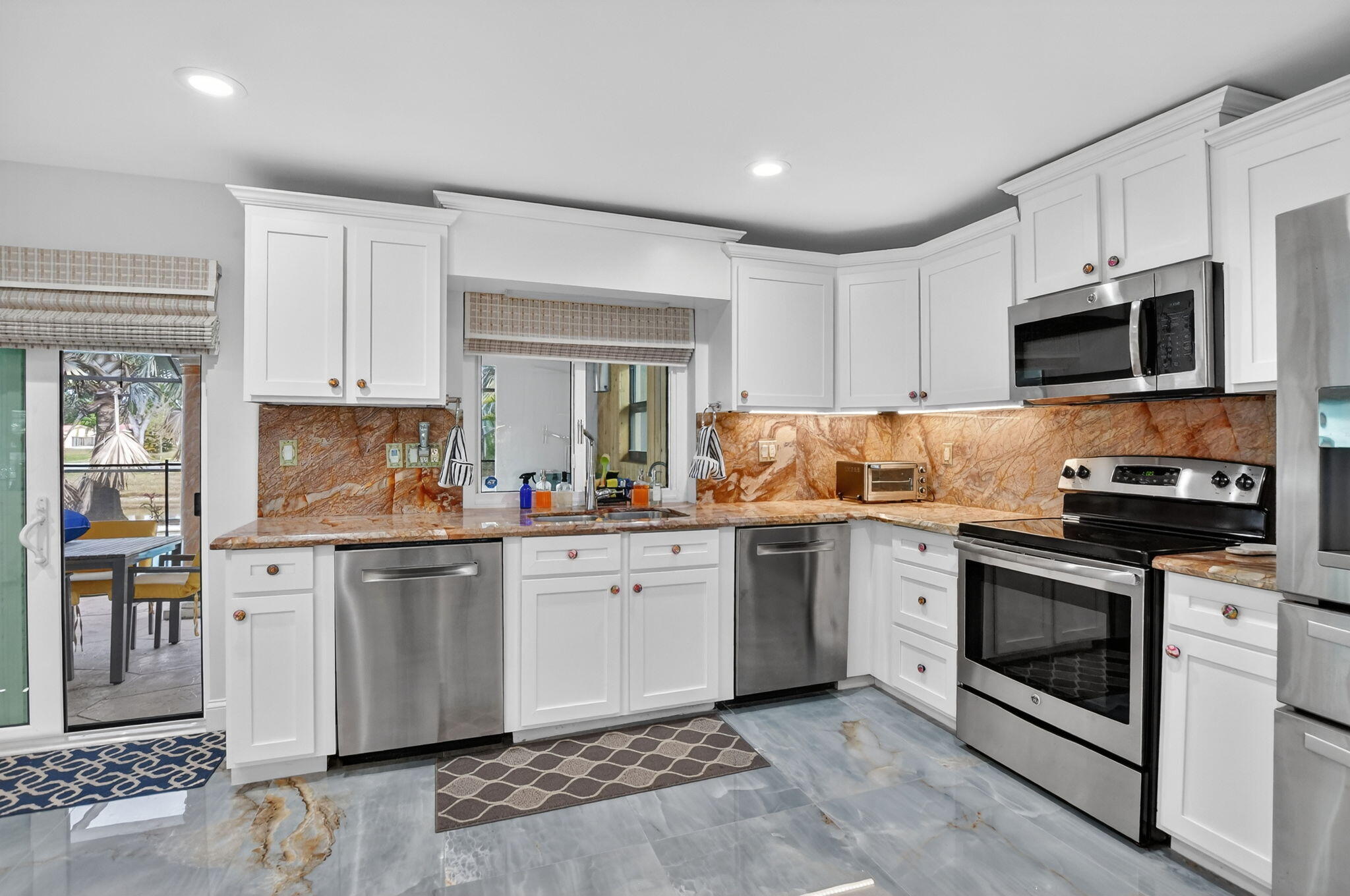 10294 Crosswind Road Boca Raton, FL 33498 - Photo 18 of 71 a kitchen with granite countertop cabinets stainless steel appliances and a window