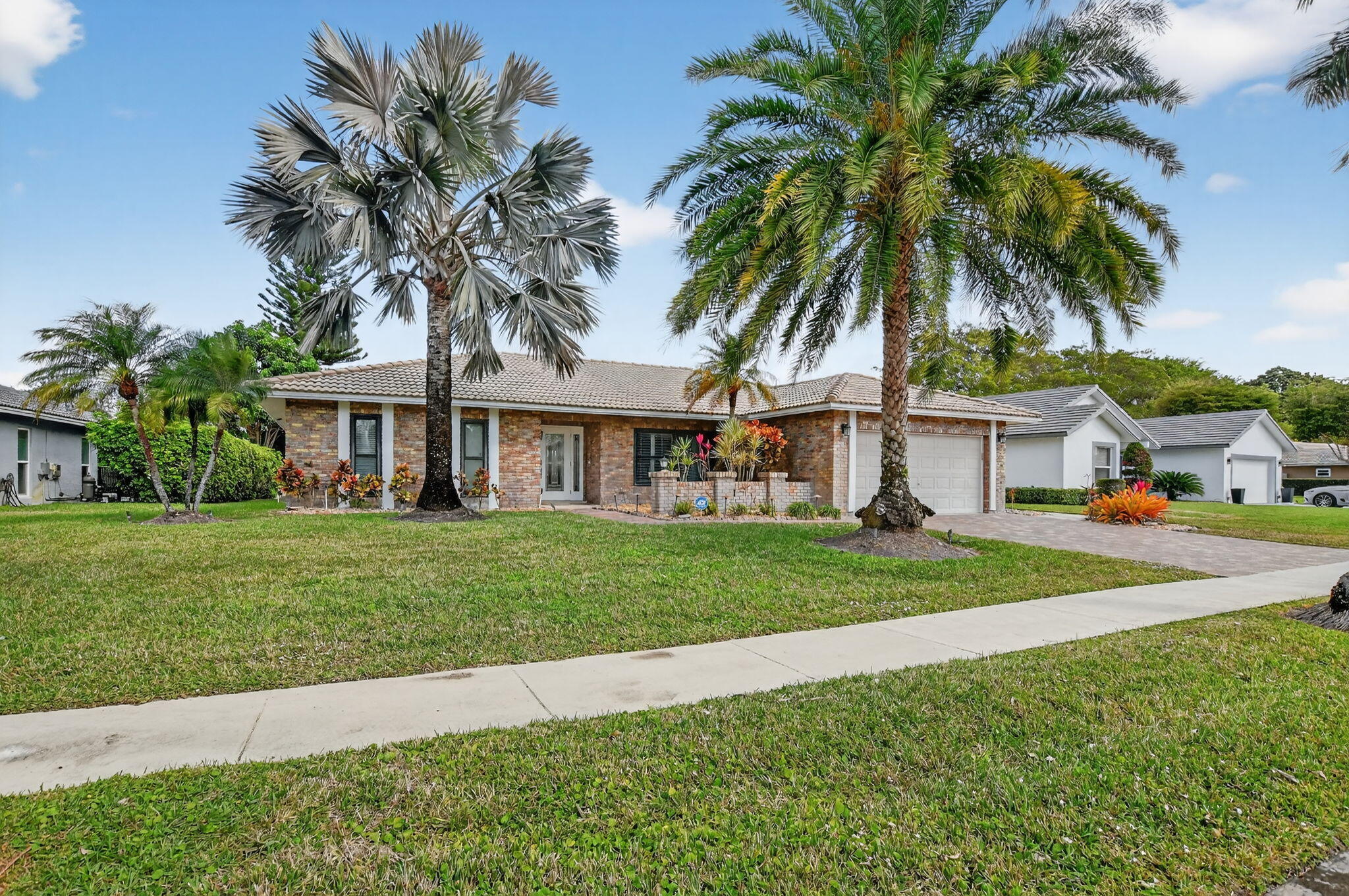 10294 Crosswind Road Boca Raton, FL 33498 - Photo 2 of 71 a front view of a house with a garden and trees