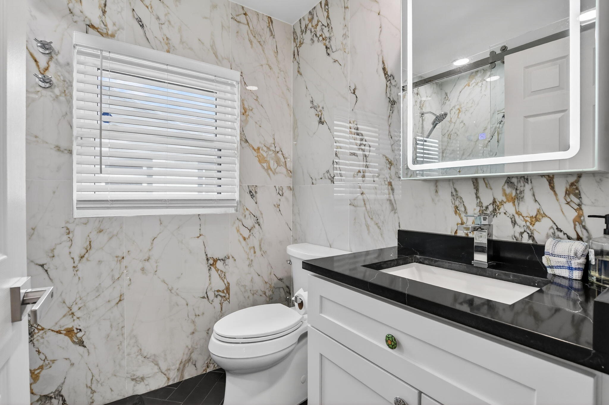 10294 Crosswind Road Boca Raton, FL 33498 - Photo 22 of 71 a bathroom with a granite countertop sink toilet and mirror