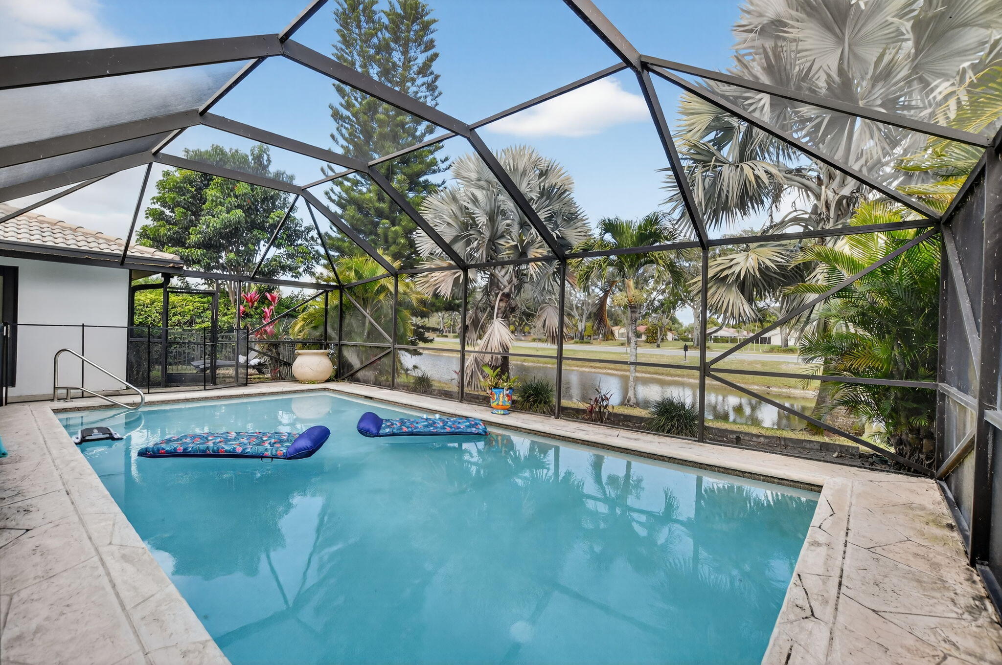 10294 Crosswind Road Boca Raton, FL 33498 - Photo 51 of 71 a view of a swimming pool with a patio and plants