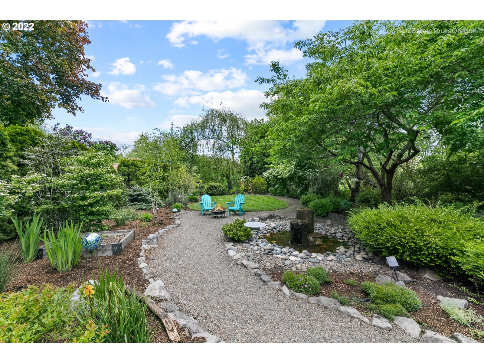 9125 Southwest Rambler Lane Portland, OR 97223 - Photo 25 of 32 a view of a garden with plants and a bench