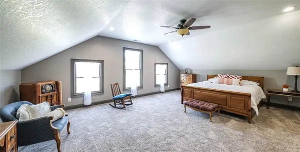 a bedroom with a bed and a flat tv screen on the dresser