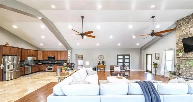 a kitchen with stainless steel appliances granite countertop a sink refrigerator and cabinets