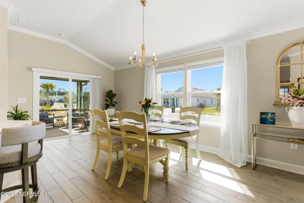 a dining room with stainless steel appliances kitchen island granite countertop a dining table and chairs