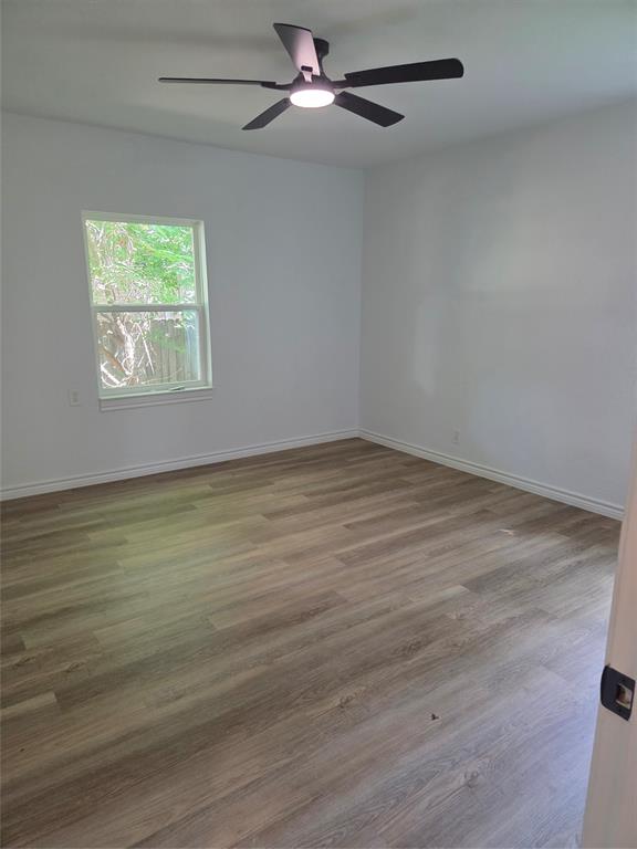 2108 Blake Avenue Dallas, TX 75228 - Photo 6 of 13 Bedroom featuring wood-finish flooring, white baseboards, and a single window