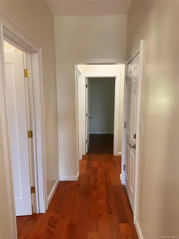 a view of a hallway with wooden floor and closet area