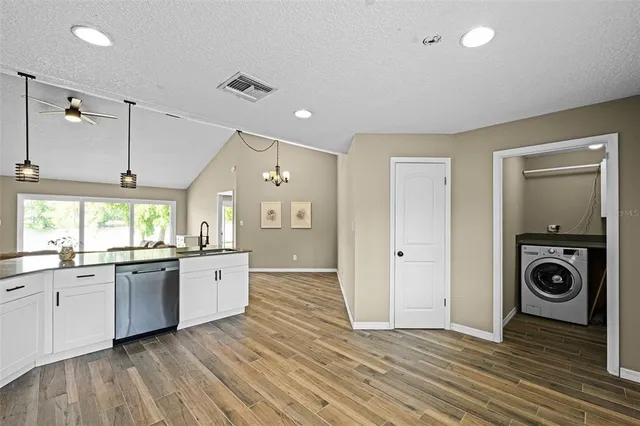 a view of a kitchen with a stove wooden floor and windows