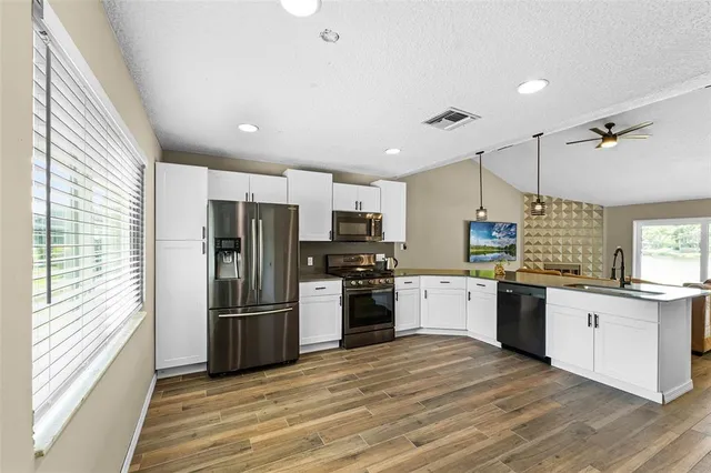 a kitchen with a refrigerator stove top oven and sink